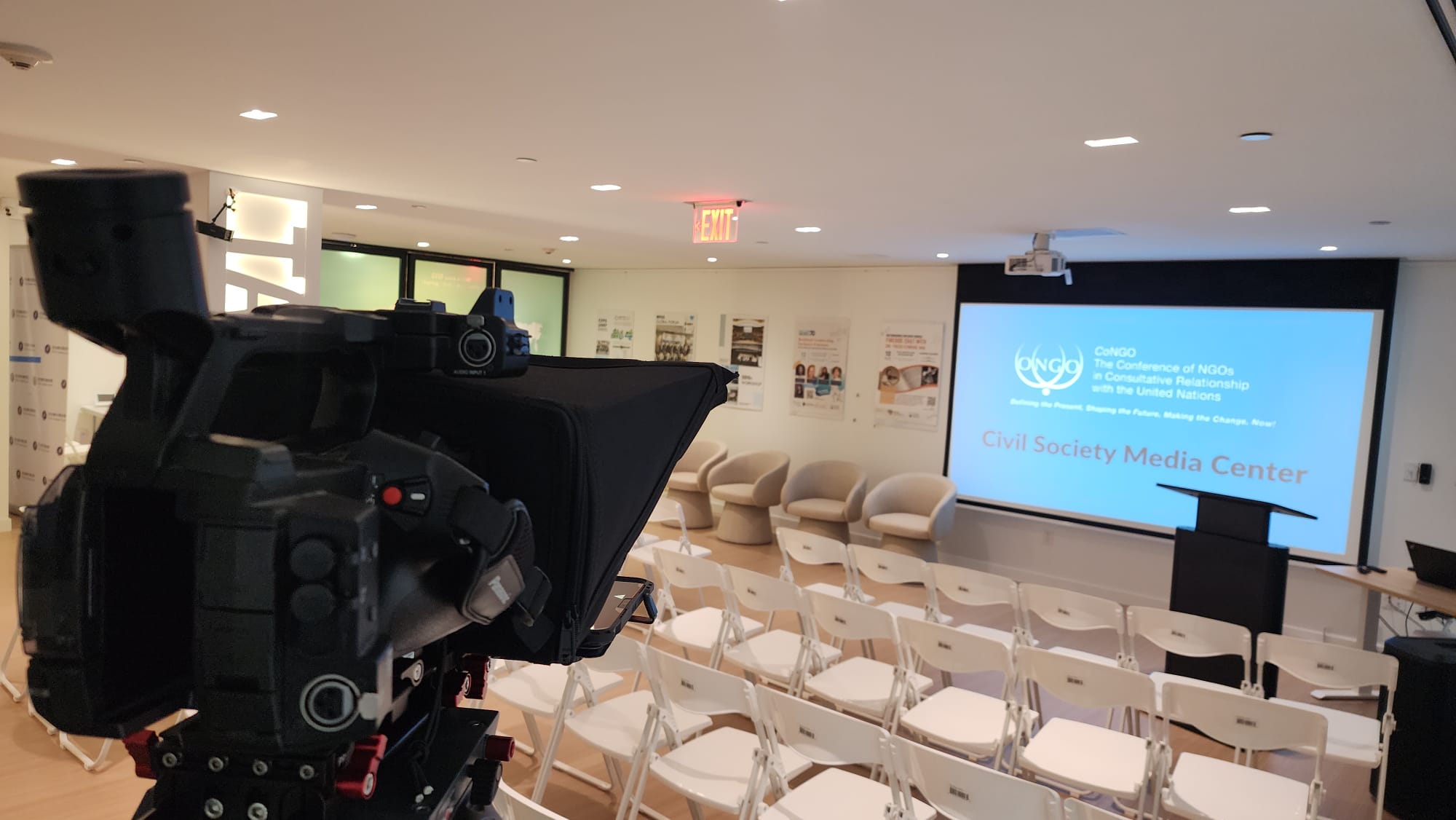 Broadcast camera with teleprompter aimed at the Civil Society Media Center screen and podium in New York